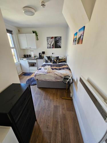 a small bedroom with a bed and a kitchen at Tiny Studio, 30 min to St. Pancras, North London in London