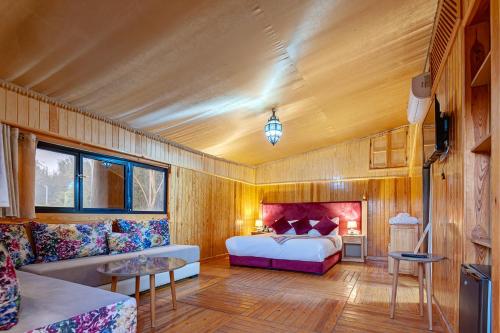 a bedroom with a bed and a couch at Ferme Sidi Safou & Spa in Marrakesh