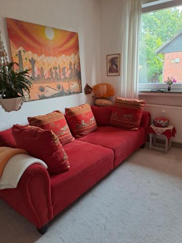 a red couch sitting in a living room at African Dream in Oldenburg