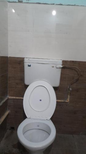 a bathroom with a white toilet in a room at Kairali Lodge in Trichūr