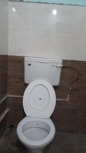 a bathroom with a white toilet in a room at Kairali Lodge in Trichūr