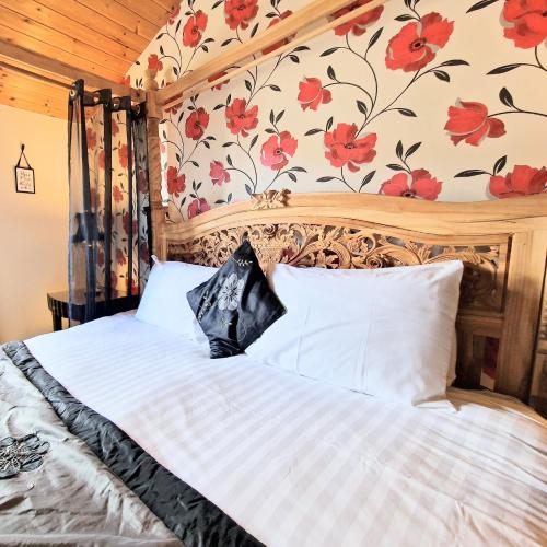 a bedroom with a large bed with flowers on the wall at Lomond 4 with Private Hot Tub - Fife - Loch Leven - Lomond Hills in Kelty