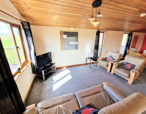 a living room with a couch and a flat screen tv at Lomond 4 with Private Hot Tub - Fife - Loch Leven - Lomond Hills in Kelty
