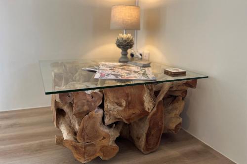 a table made out of a tree stump with a glass top at The Tower Simonsbath in Simonsbath