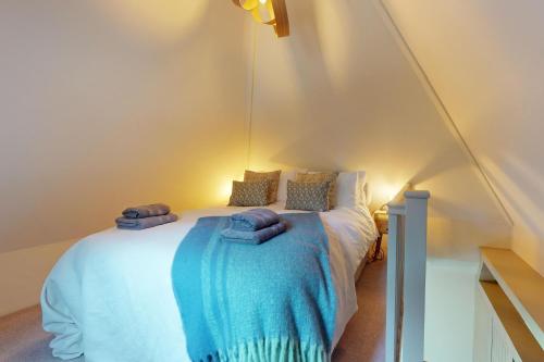 a bedroom with a bed with blue sheets and pillows at The Tower Simonsbath in Simonsbath
