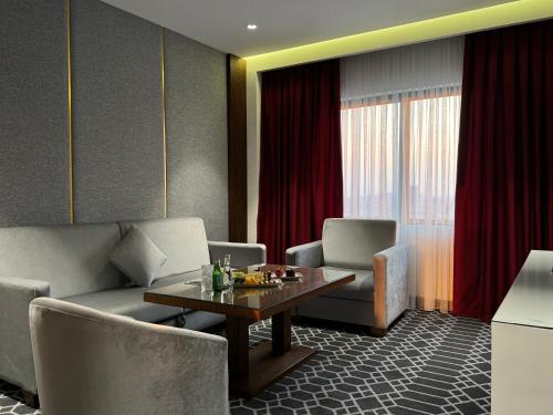 a living room with a table and chairs at Ankawa Holiday Hotel in Erbil