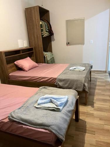 two beds in a room with towels on them at Ribas Pousada e Camping in Carambeí