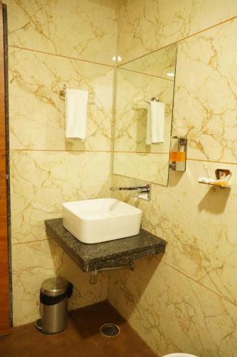 W łazience znajduje się umywalka i lustro. w obiekcie SoonStay Heera Residency w mieście Bhopal