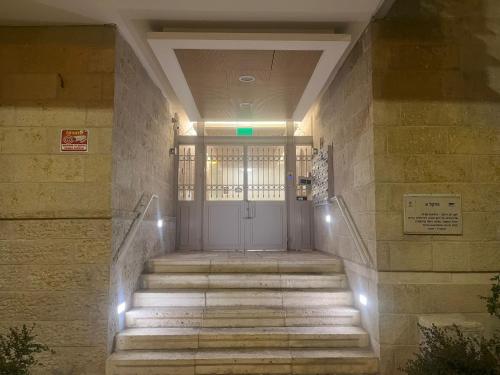 uma porta da frente de um edifício com escadas e luzes em The best location in Jerusalem2 em El Muṣrāra