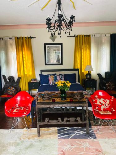um quarto com uma cama e 2 cadeiras vermelhas em Casa de Roy em Kampala