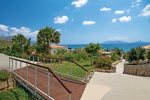 a stairway with a hand rail and the ocean at Grand Blue Beach Hotel in Kardamaina