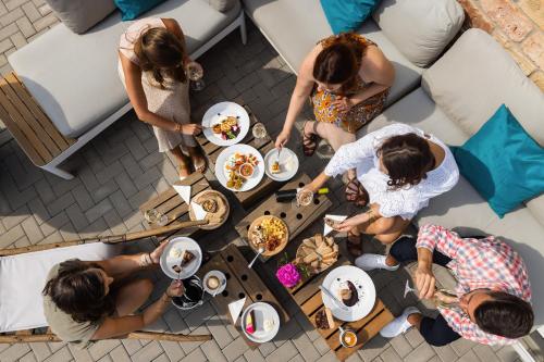 grupa ludzi stojących przy stole z jedzeniem w obiekcie Penzion jako víno w mieście Bulhary