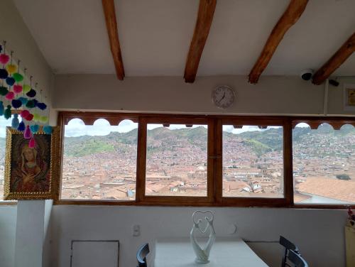 a view of a city from a window with a clock at Black Sheep Hostel Cusco in Cusco