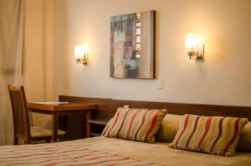 Una habitación de hotel con una cama con dos almohadas. en Grand Hotel en San Fernando del Valle de Catamarca