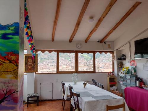a dining room with a table and some windows at Black Sheep Hostel Cusco in Cusco