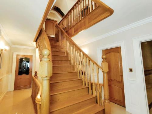 a wooden staircase in a home with wooden railings at 'Emily' Deluxe Family Room in Foxford