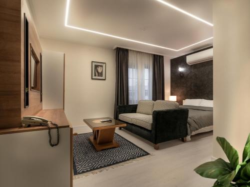 ein Hotelzimmer mit einem Bett und einem Sofa in der Unterkunft Prestige Hotel Suites - برستيج للشقق الفندقية in Amman