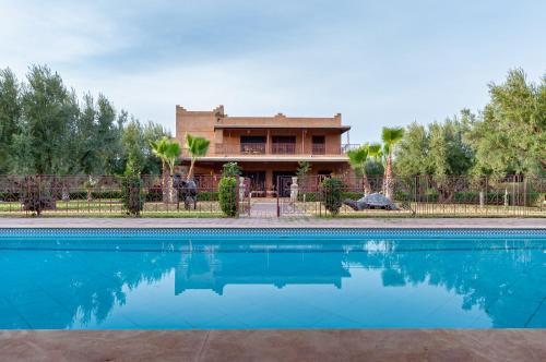 uma casa com piscina em frente a uma casa em Ferme Sidi Safou & Spa em Marrakech