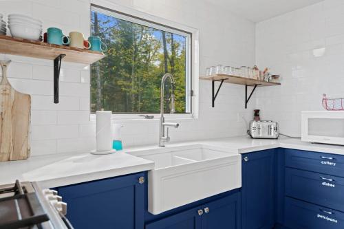 a kitchen with blue cabinets and a sink at Muskokan Mirage Located on Mirage Lake in Novar