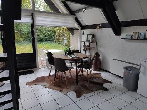 a kitchen with a table and chairs in a room at vrijstaande recreatiebungalow met slaapvide in Posterholt