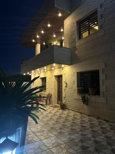 a building with a patio at night with lights at Jerash City View in Jerash