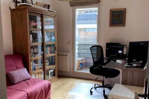een woonkamer met een bureau, een stoel en een computer bij Appartement de standing calme idéal pour les JO ! in Suresnes
