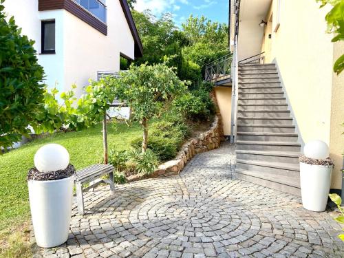 un banc assis devant une maison avec des escaliers dans l'établissement Relax-Fewo-Rösch, à Trechtingshausen