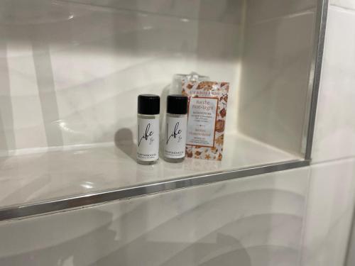 twee flessen odorizers op een plank in een badkamer bij Pina’s home in Trieste
