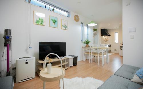 a living room with a couch and a dining room at Skytree Cozy House in Tokyo