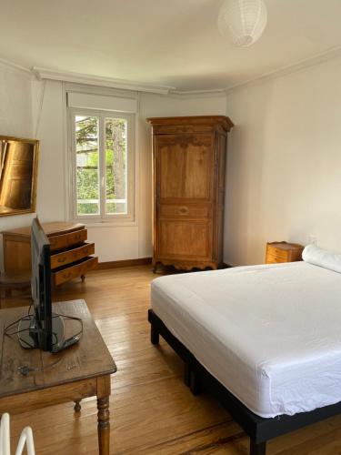 - une chambre avec un lit et une télévision sur une table dans l'établissement Élégante Villa centre ville Royan proche plages 3 chambres 3 grands lits, à Royan