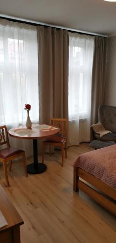 - un salon avec une table et un vase dans l'établissement Apartamenty Po Kominiarzach I, à Chełmno