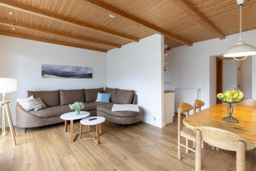 a living room with a couch and a table at Deich-Bungalow Königsberger Allee 30 APPARTO Grömitz in Grömitz