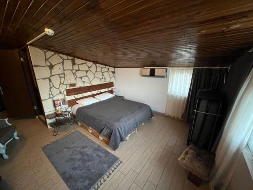 a bedroom with a bed and a stone wall at hotel budapest in Seferihisar