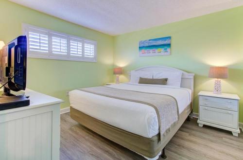 a bedroom with a bed and a television in it at 0306 Oceanfront Oasis by Atlantic Towers in Carolina Beach