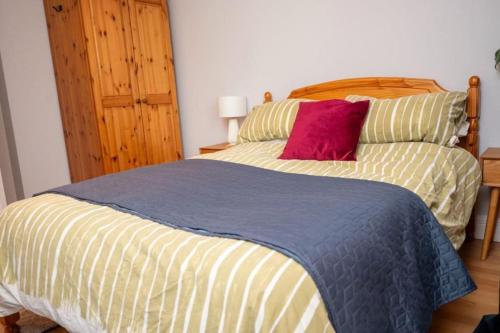 a bedroom with a large bed with a red pillow at Modern apartment in the Heart of Sligo Town in Sligo