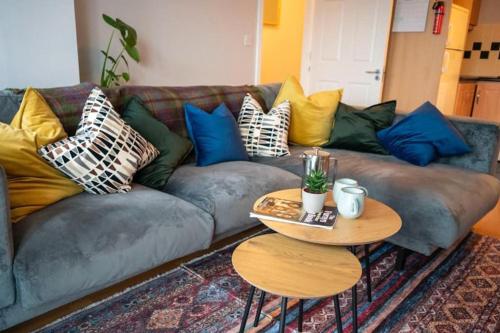a living room with a couch with pillows and a table at Modern apartment in the Heart of Sligo Town in Sligo