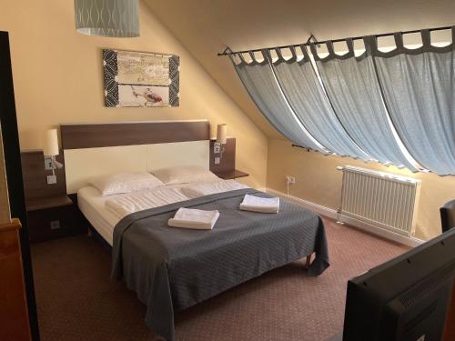 una camera da letto con un letto con due asciugamani sopra di Boulevard City Panzió - self check-in a Budapest
