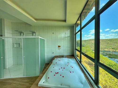 a large bathroom with a shower and a large window at Hotel Aconchego do Velho Chico in Piranhas