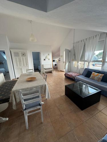 ein Wohnzimmer mit einem Tisch und einem blauen Sofa in der Unterkunft Son de Mar 2 in Bolonia