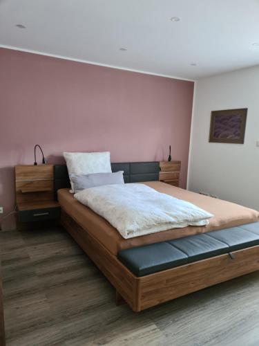 een slaapkamer met een groot bed met een houten frame bij Ferienwohnung Burgblick in Pelm