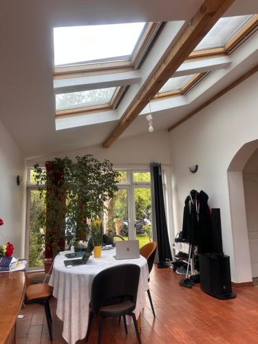 un salon avec une table avec un ordinateur portable dessus dans l'établissement Maison proche Paris, à Colombes