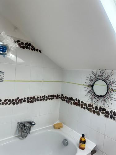 a bathroom with a tub with a mirror and a sink at Maison avec Jardin proche Porte Maillot in Colombes