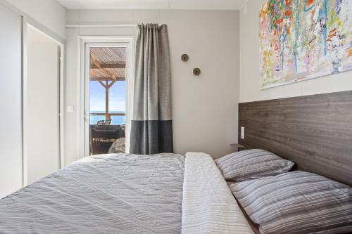 een slaapkamer met een groot bed en een raam bij Domaine Ile d'or, bungalow Segur 8 in Saint-Raphaël