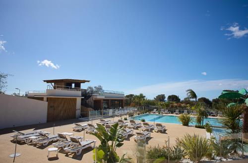un complexe avec piscine et chaises longues dans l'établissement Bungalow avec terrasse vue mer, à Saint-Raphaël