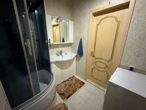Rakhat的住宿－ЖК Сезам，带淋浴、盥洗盆和淋浴门的浴室