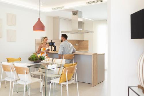 un hombre y una mujer de pie en una cocina en Apartamentos Martalia - La Casa del Cedro Luxury, en Ronda