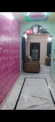 a living room with a couch and a pink wall at Avinash residency in Bhadrāchalam