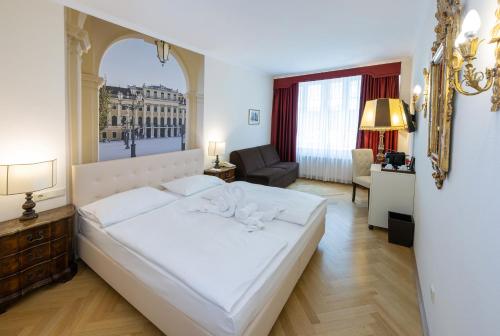 a bedroom with a large white bed and a living room at Hotel Royal in Vienna