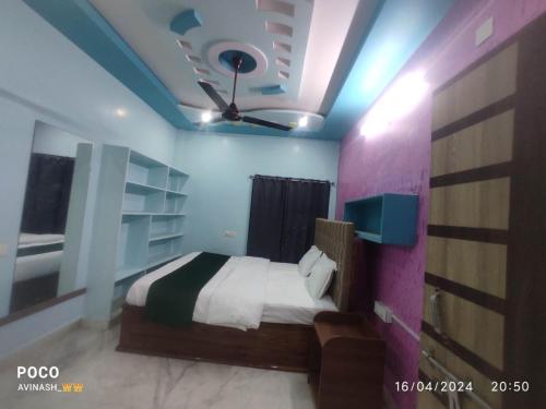a bedroom with a bed and a ceiling fan at Avinash residency in Bhadrāchalam