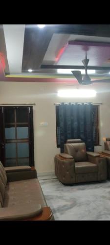 a living room with two couches and a ceiling at Avinash residency in Bhadrāchalam